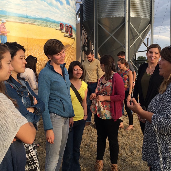 Students listen to a speaker at a grain farm