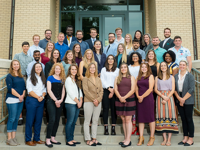 Graduate students stand outside Rockwell Hall