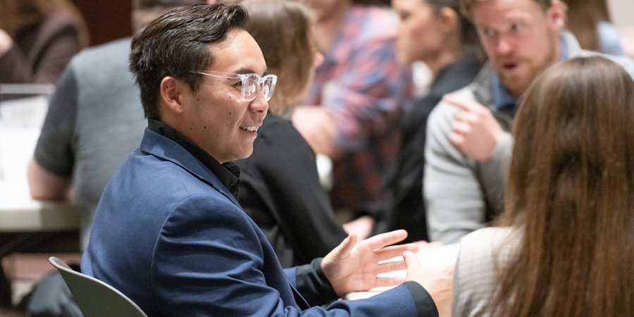 Two people chat at a CSU College of Business event.