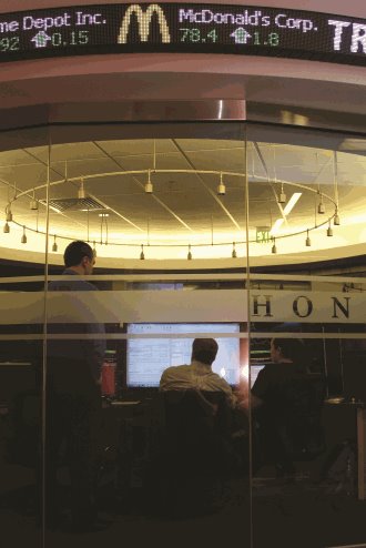 Students sitting and standing around a Bloomberg terminal.