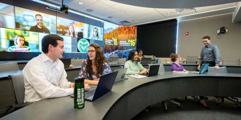 Two MBA students discuss an assignment in class.