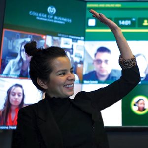 An online MBA student raises her hand in class