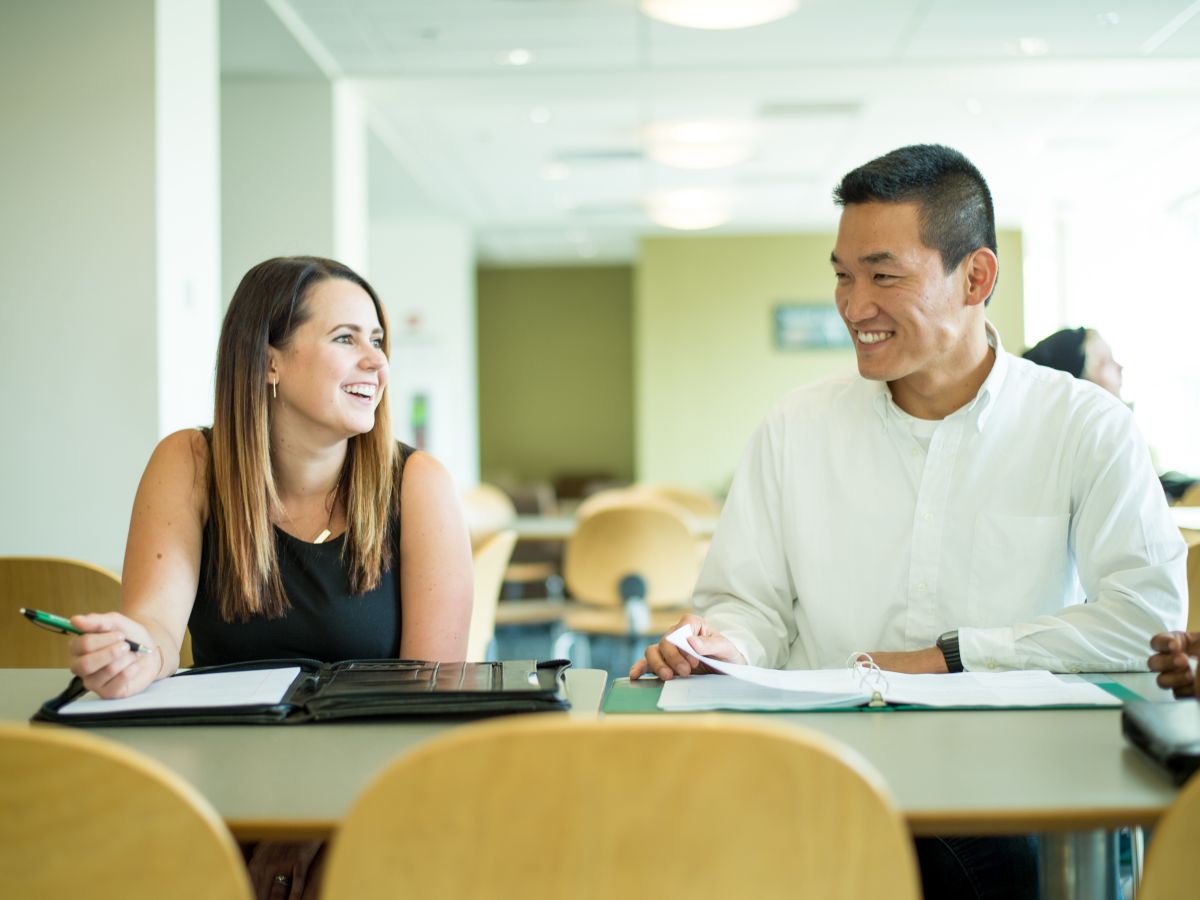 Two MBA students discuss an assignment during a study session.