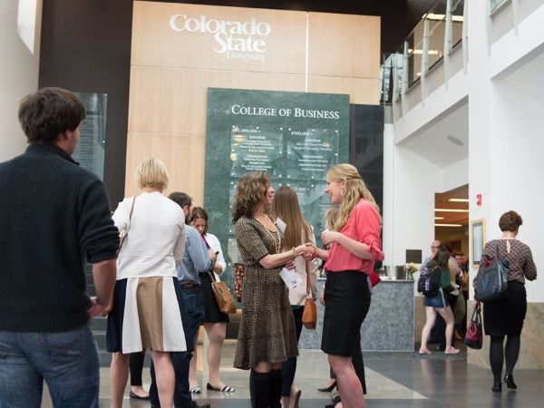 Two people chat at a CSU College of Business event.