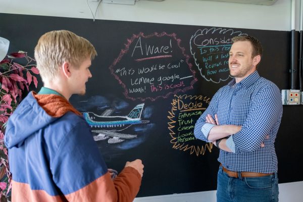 Institute for Entrepreneurship Director Scott Shrake talks with a student during an activity in the Venture Lounge.