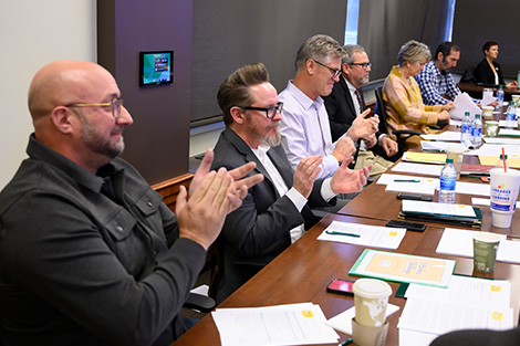 A group of judges clap for a case competition presentation