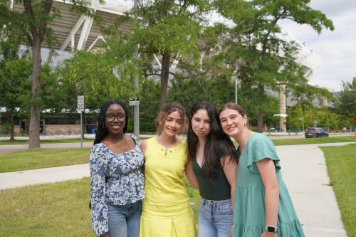 A group of Global Business Academy students pose for a photo outside of CSU's Canvas Stadium.
