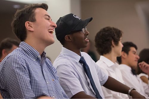 A Global Business Academy student laughs in delight during a speaker presentation.