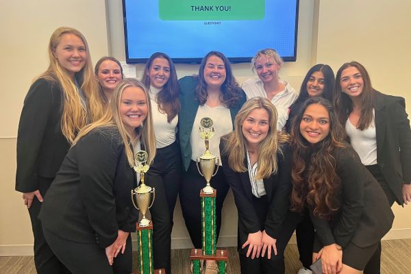 Women In Business Association members pose for a photo with a case competition trophy.