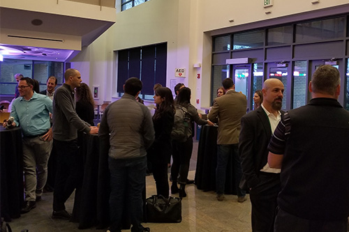 A group of people gather and network during the Supply Chain Management Forum