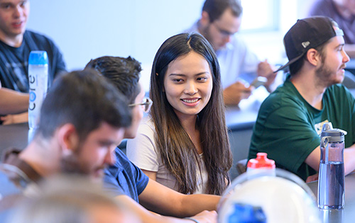 Two students discuss an assignment in class.