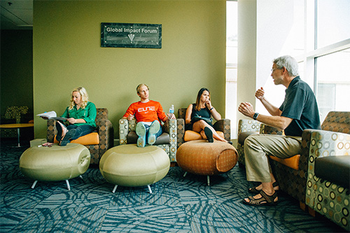 A business professor meets with students