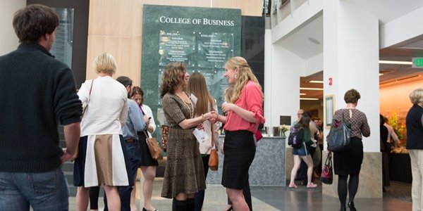 Two women chat at a networking event at CSU's College of Business.