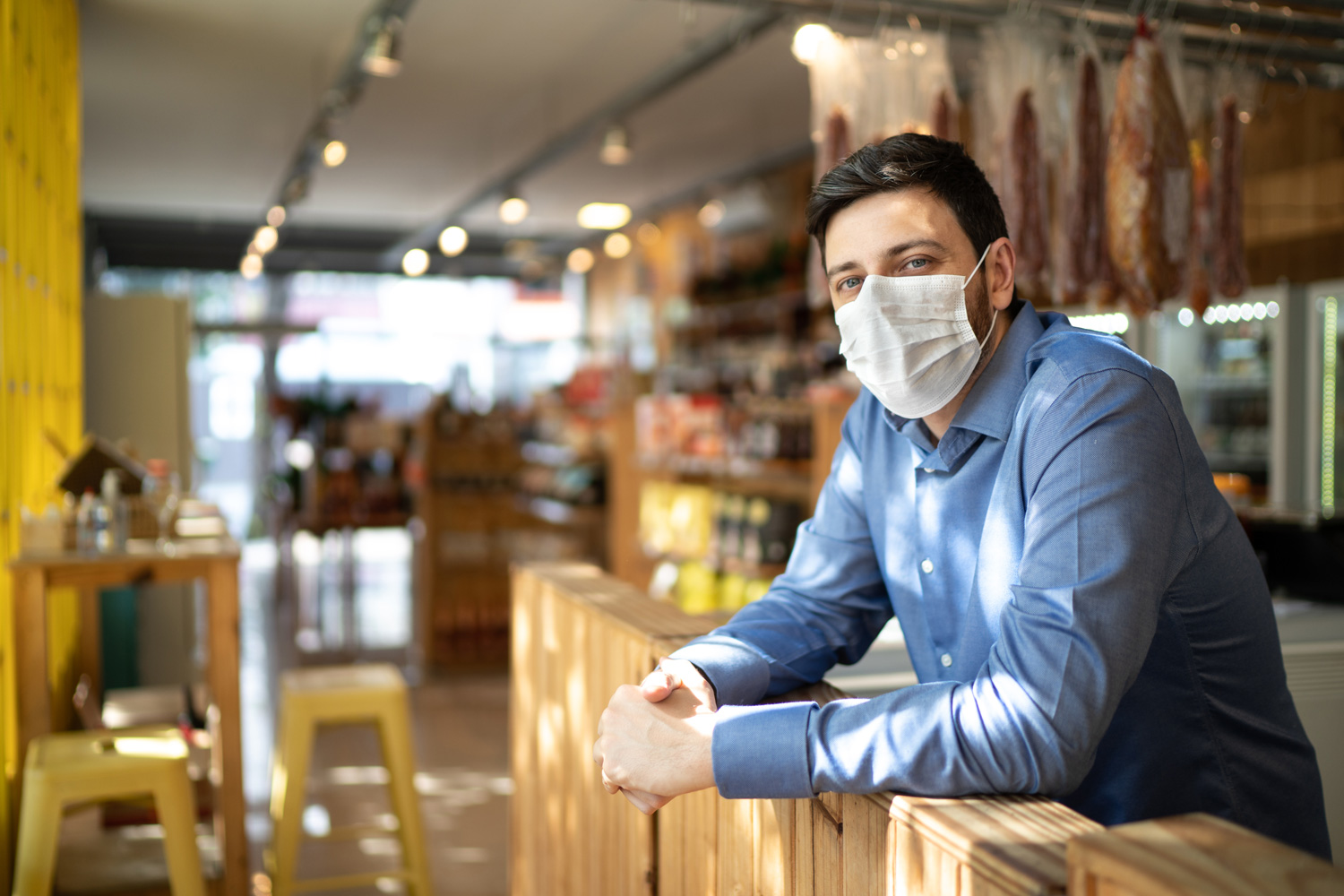 man standing in business wearing a covid-19 mask