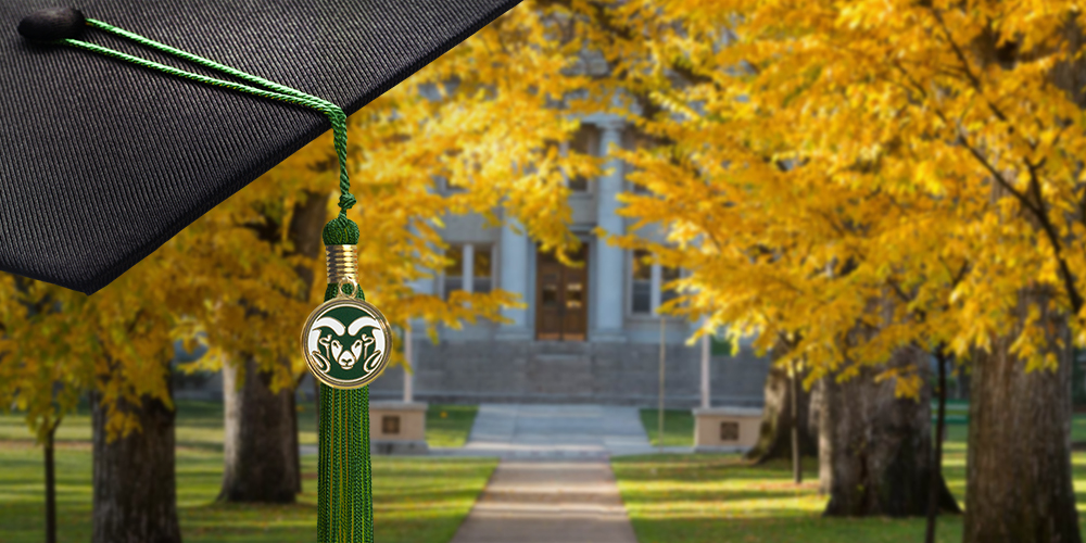 A graduation cap with the CSU rams logo on the tassel is held in front of the Oval