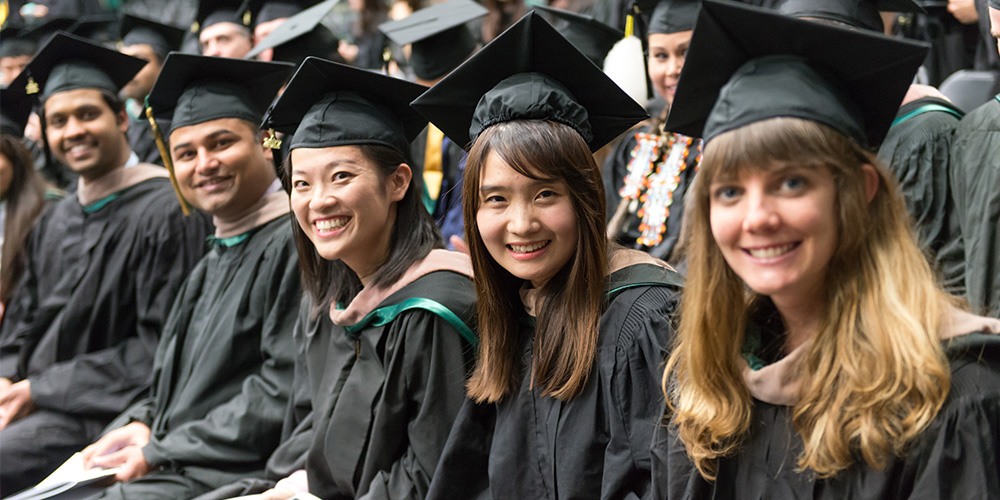 A group of students smile as they wait for the Commencement Ceremony to begin