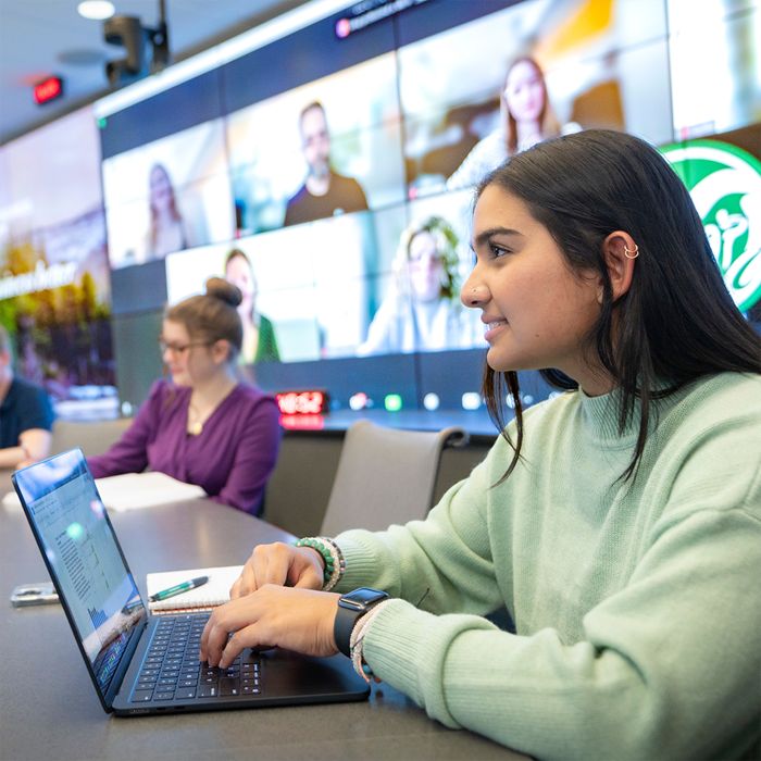 Mosaic MBA students participate in a lecture in person and online via videoconference.