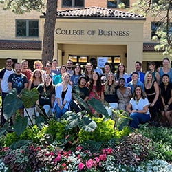 The Impact MBA Graduate Students pose for a photo outside of Rockwell Hall