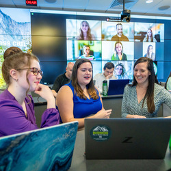 Dr. Elizabeth Cowle works with some students in the Mosaic MBA classroom.