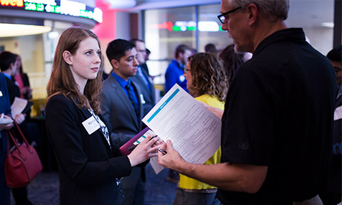 A business student converses with a professor