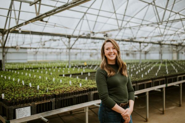 Impact MBA alum Katelynn Martinez poses for a photo in the conservation nursery of OneCanopy, the nonprofit she cofounded.