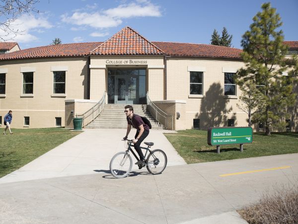 A student bikes on the mixed-use trail outside Rockwell Hall.