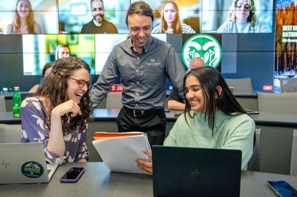 Two women at a table in a cafe examine a note.