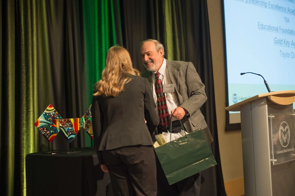A student accepts an award at the Accounting Awards Ceremony