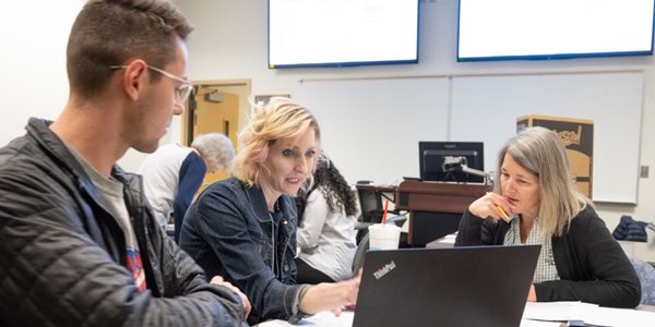 Professor Mandy Sharpe and an accounting student help a community member prep their tac return during the College's annual free tax preparation event.