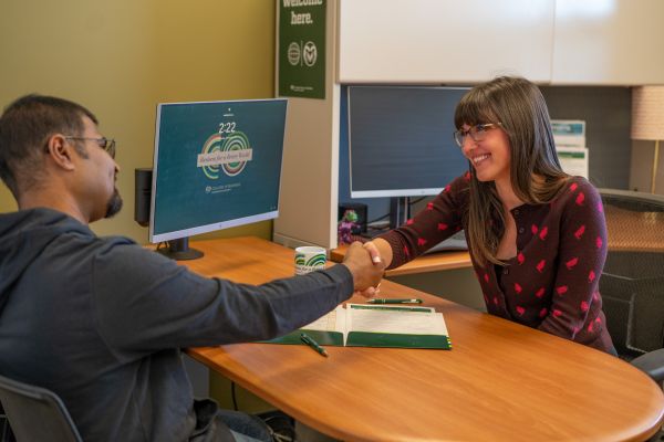 A Career Management Center counselor shakes hands with a student.