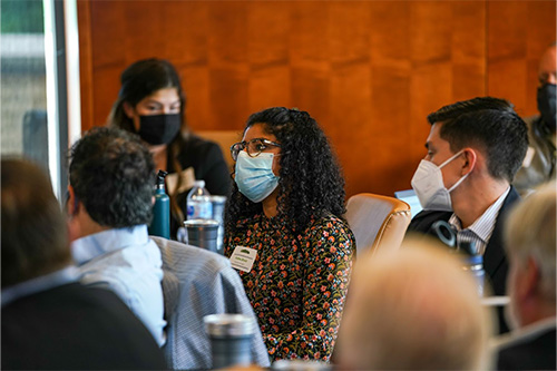 A group of people wearing masks listen to a lecture