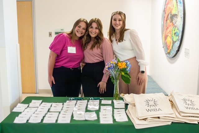 Women in Business Association student leadership pose for a photo at a tabling event.
