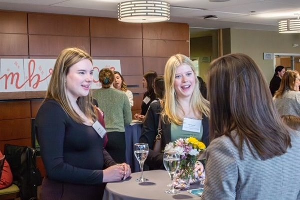 Students and community members chat at a Women in Business Association event.